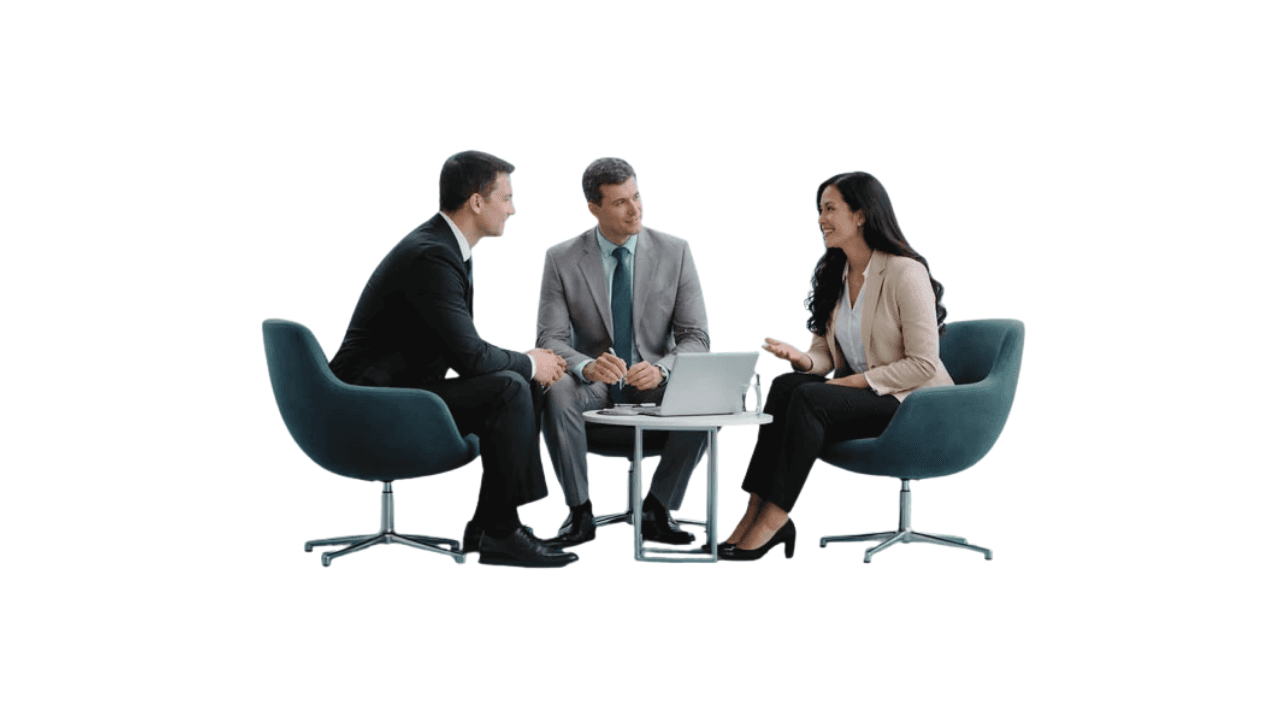 Three professionals meeting around a low table with a laptop, the photograph for Storyline Pros media and outlet positioning.
